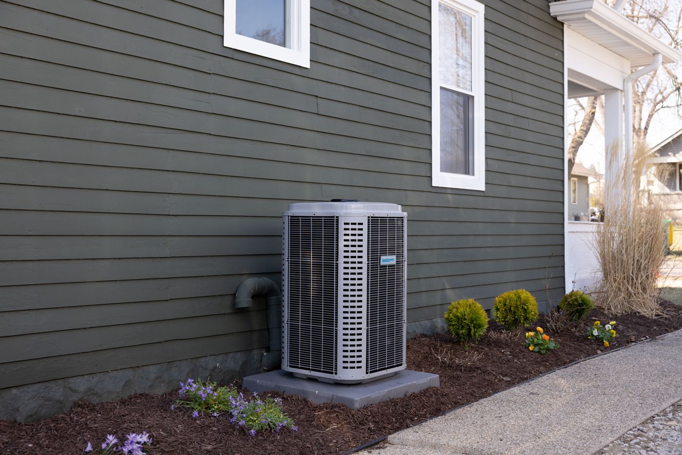A new condenser, set clean beside the house